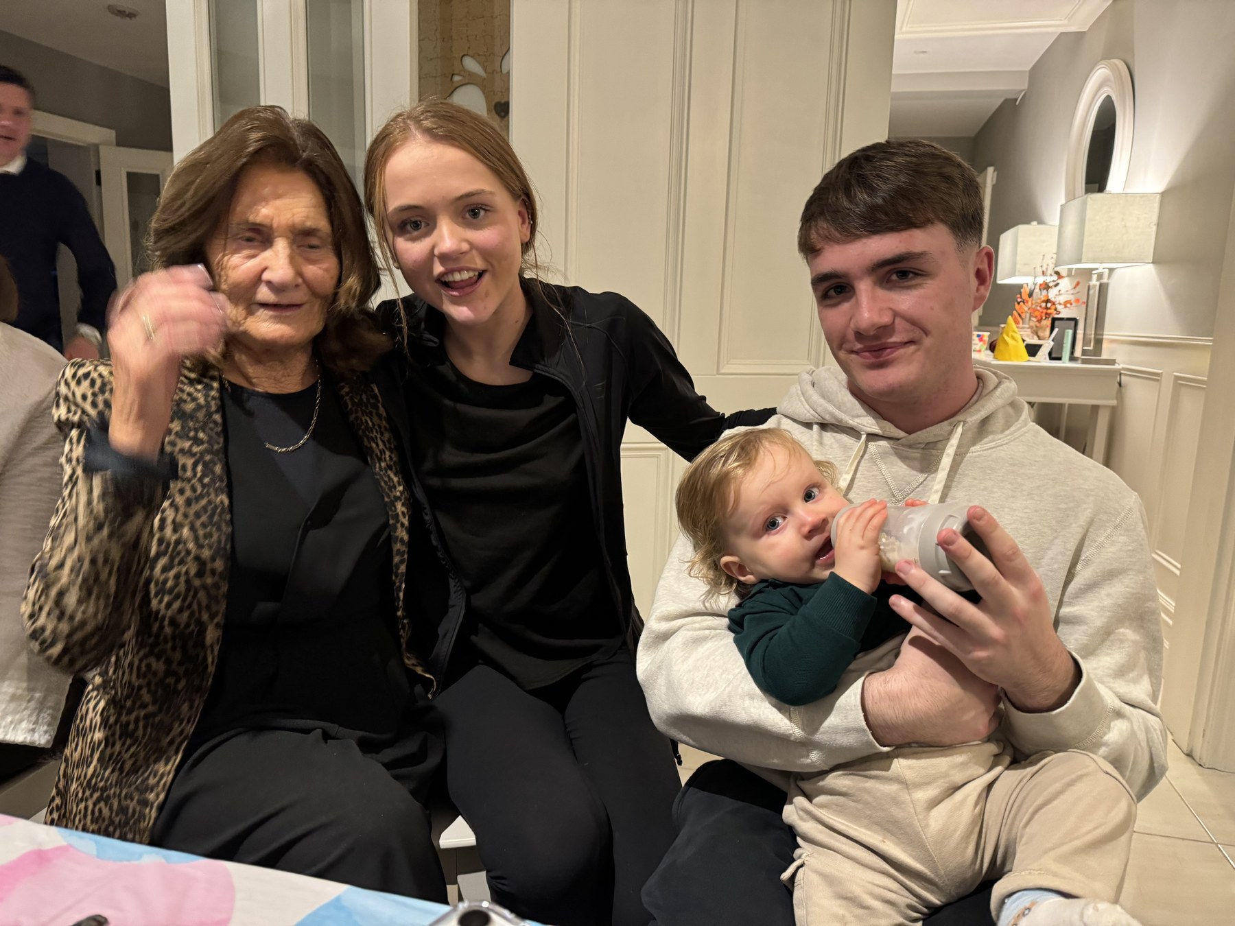 A group sitting close together indoors, including a small child being held.